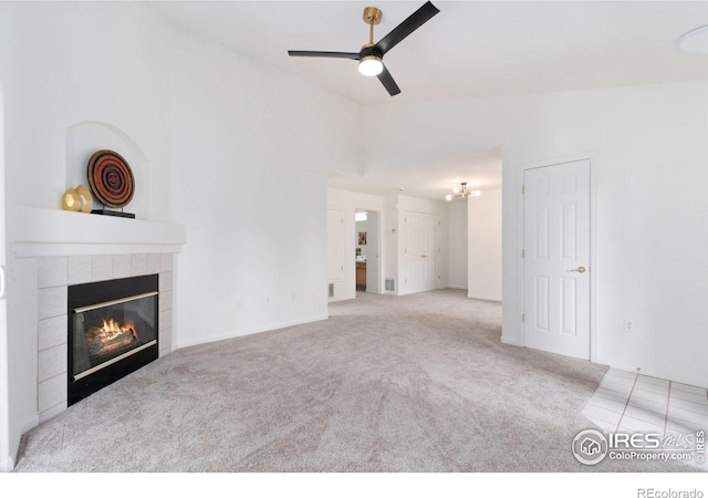 3350 Boulder Cir Unit 201, Broomfield, CO 80023 - unfurnished living room featuring carpet flooring, a tiled fireplace, a ceiling fan, lofted ceiling, and a chandelier