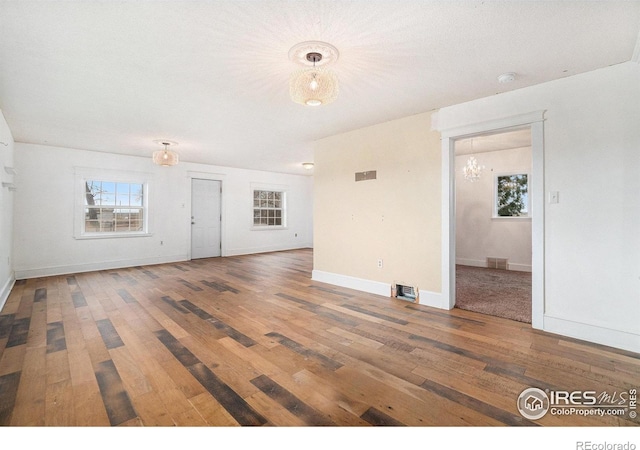 2118 N 47th Ave, Greeley, CO 80631 - unfurnished living room featuring a chandelier and hardwood / wood-style flooring