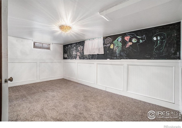 2118 N 47th Ave, Greeley, CO 80631 - unfurnished room featuring carpet floors, a wainscoted wall, and a decorative wall