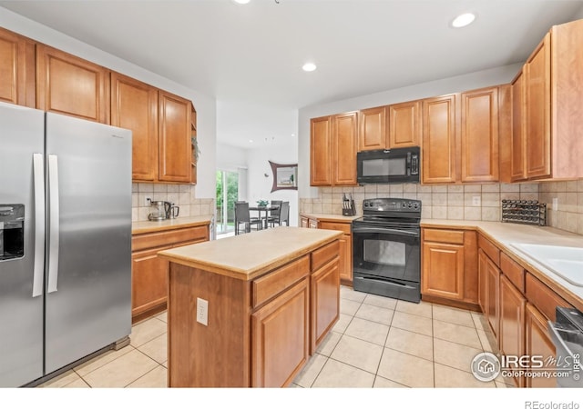 502 Peregrine Cir, Longmont, CO 80504 - kitchen featuring black appliances, light tile patterned floors, backsplash, a center island, and light countertops