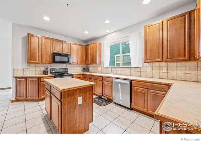 502 Peregrine Cir, Longmont, CO 80504 - kitchen with black appliances, light countertops, a kitchen island, light tile patterned floors, and decorative backsplash