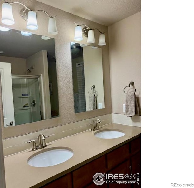 6340 Orchard Park Dr Unit 2, Greeley, CO 80634 - bathroom featuring double vanity, a shower stall, and a textured ceiling