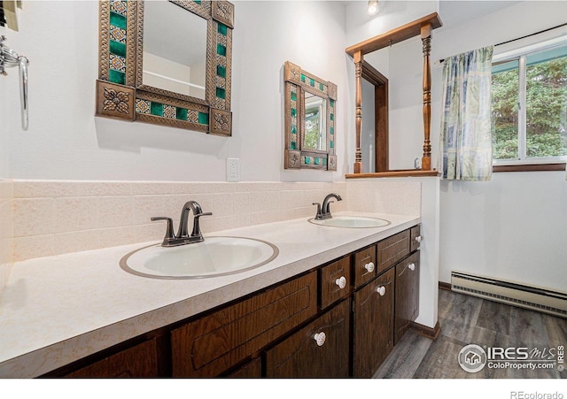 37416 County Road 45, Eaton, CO 80615 - bathroom with a baseboard heating unit, double vanity, and wood finished floors