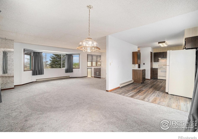 37416 County Road 45, Eaton, CO 80615 - unfurnished living room featuring baseboard heating, carpet floors, and a chandelier