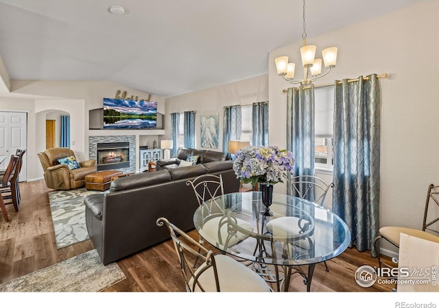 1703 Whitehall Dr Unit G, Longmont, CO 80504 - dining room with a chandelier, vaulted ceiling, wood finished floors, and a fireplace
