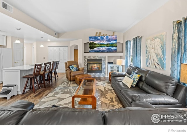 1703 Whitehall Dr Unit G, Longmont, CO 80504 - living area featuring light wood finished floors, lofted ceiling, and a stone fireplace