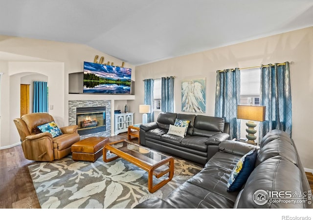 1703 Whitehall Dr Unit G, Longmont, CO 80504 - living room featuring wood finished floors, vaulted ceiling, and a stone fireplace