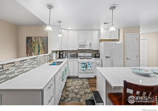 1703 Whitehall Dr Unit G, Longmont, CO 80504 - kitchen with white appliances, white cabinetry, decorative backsplash, dark wood finished floors, and light stone countertops