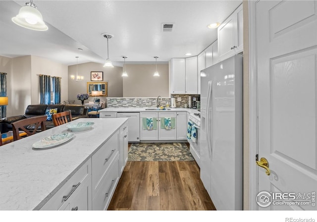 1703 Whitehall Dr Unit G, Longmont, CO 80504 - kitchen with white appliances, dark wood-style floors, white cabinets, light stone counters, and decorative light fixtures