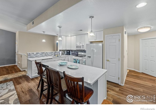 1703 Whitehall Dr Unit G, Longmont, CO 80504 - kitchen featuring white appliances, tasteful backsplash, white cabinets, pendant lighting, and recessed lighting