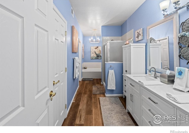 1703 Whitehall Dr Unit G, Longmont, CO 80504 - full bath featuring a chandelier, a stall shower, vanity, wood finished floors, and a bath