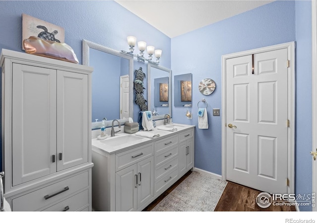 1703 Whitehall Dr Unit G, Longmont, CO 80504 - full bath with double vanity, wood finished floors, and a textured wall