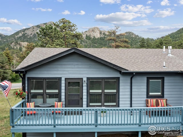 1316 Kinnikinnic Ct, Estes Park, CO 80517 - view of front facade featuring a deck with mountain view and a shingled roof