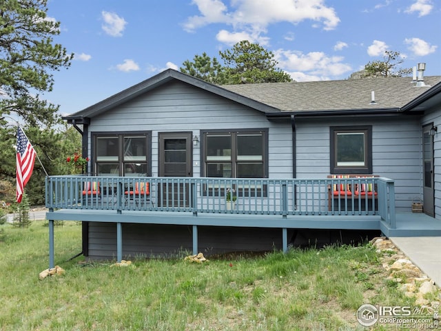 1316 Kinnikinnic Ct, Estes Park, CO 80517 - view of front facade with a wooden deck, a front lawn, and a shingled roof