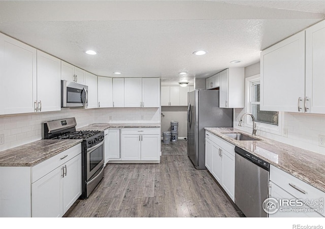 8416 Peakview Dr, Fort Collins, CO 80528 - kitchen with appliances with stainless steel finishes, light stone countertops, decorative backsplash, a textured ceiling, and recessed lighting