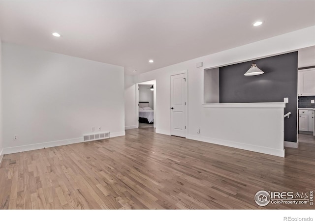 8696 W 86th Cir, Arvada, CO 80005 - unfurnished living room featuring light wood-style floors and recessed lighting