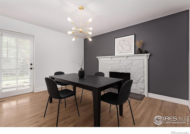 8696 W 86th Cir, Arvada, CO 80005 - dining area with wood finished floors, a chandelier, and a fireplace