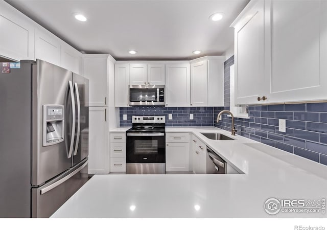 8696 W 86th Cir, Arvada, CO 80005 - kitchen featuring appliances with stainless steel finishes, light countertops, white cabinetry, decorative backsplash, and recessed lighting