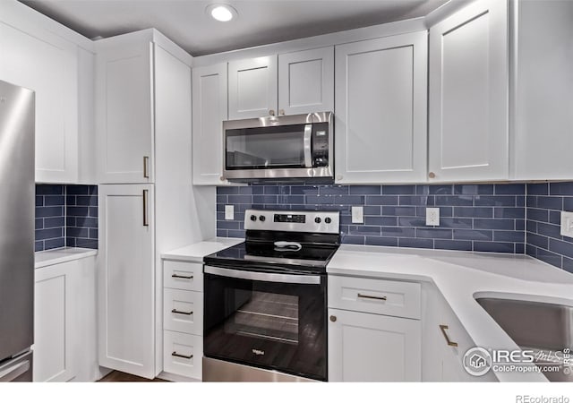 8696 W 86th Cir, Arvada, CO 80005 - kitchen with stainless steel appliances, light countertops, backsplash, and white cabinetry