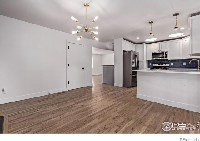 8696 W 86th Cir, Arvada, CO 80005 - kitchen featuring appliances with stainless steel finishes, wood finished floors, decorative backsplash, white cabinets, and recessed lighting