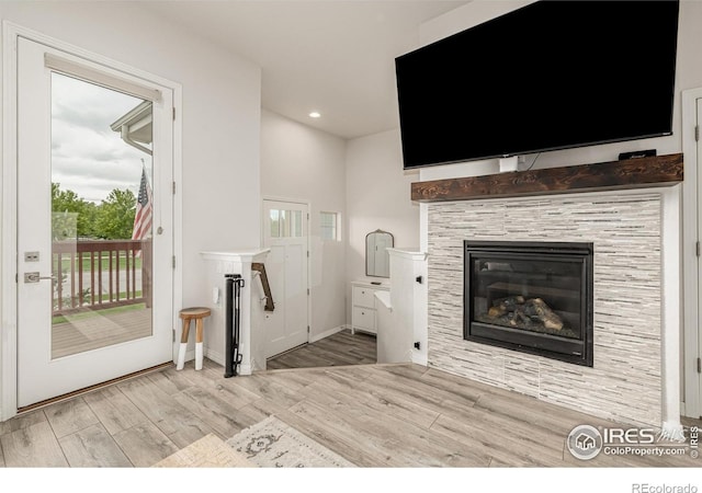 619 Brennan Cir, Erie, CO 80516 - living area featuring wood finished floors, plenty of natural light, recessed lighting, and a tiled fireplace