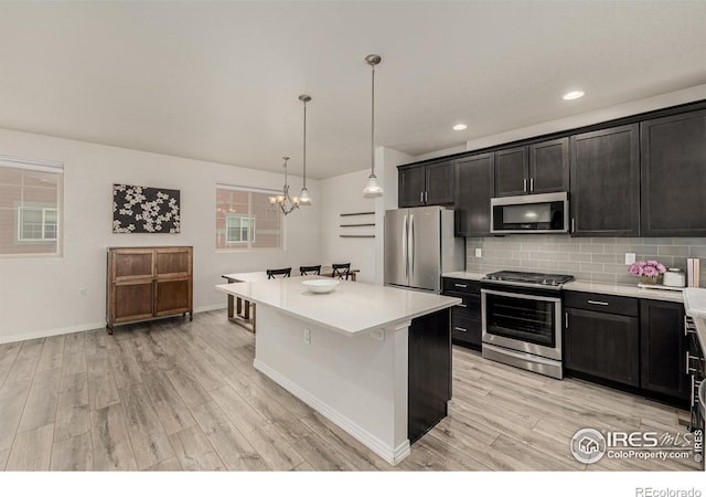 619 Brennan Cir, Erie, CO 80516 - kitchen featuring stainless steel appliances, light countertops, a chandelier, light wood-style floors, and recessed lighting
