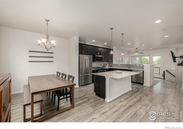 619 Brennan Cir, Erie, CO 80516 - kitchen featuring appliances with stainless steel finishes, a center island, light countertops, recessed lighting, and light wood-style flooring