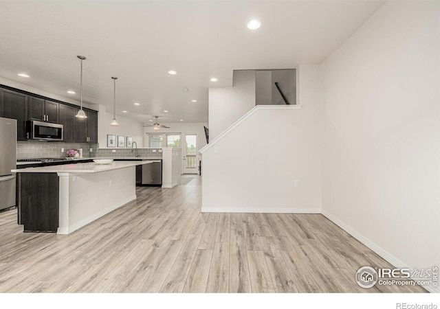 619 Brennan Cir, Erie, CO 80516 - kitchen featuring appliances with stainless steel finishes, a kitchen island, light countertops, recessed lighting, and backsplash