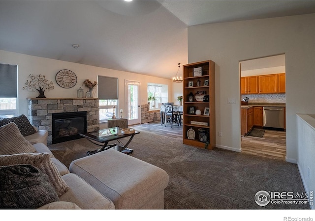 14053 Cottonwood Cir, Sterling, CO 80751 - carpeted living area with lofted ceiling, a stone fireplace, and a chandelier