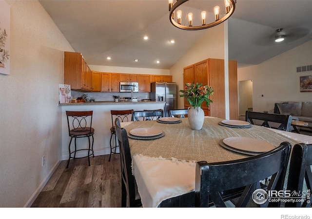 14053 Cottonwood Cir, Sterling, CO 80751 - dining area featuring lofted ceiling, dark wood-style flooring, recessed lighting, and a chandelier