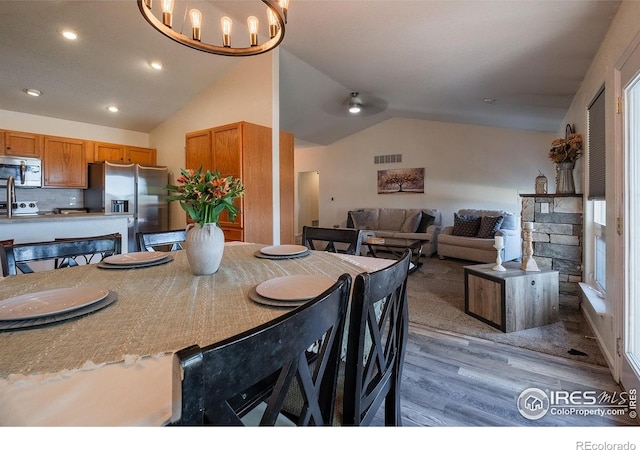 14053 Cottonwood Cir, Sterling, CO 80751 - dining space featuring wood finished floors, vaulted ceiling, recessed lighting, and a chandelier