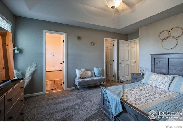 14053 Cottonwood Cir, Sterling, CO 80751 - carpeted bedroom featuring a raised ceiling, connected bathroom, and ceiling fan