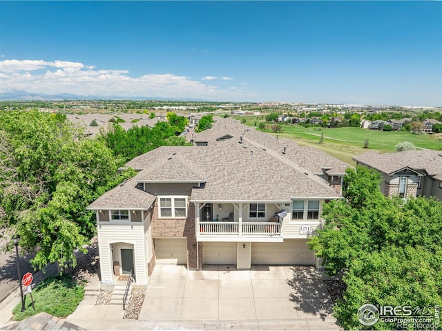 12912 Grant Cir E # A, Thornton, CO 80241 - view of front of home with an attached garage, concrete driveway, roof with shingles, and brick siding