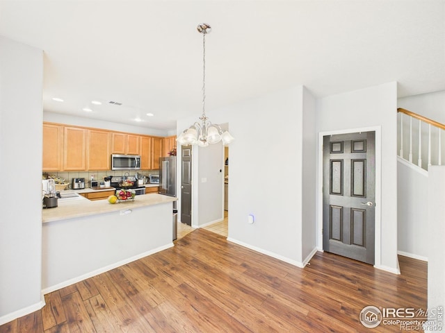 12912 Grant Cir E # A, Thornton, CO 80241 - kitchen with appliances with stainless steel finishes, light countertops, wood finished floors, tasteful backsplash, and recessed lighting