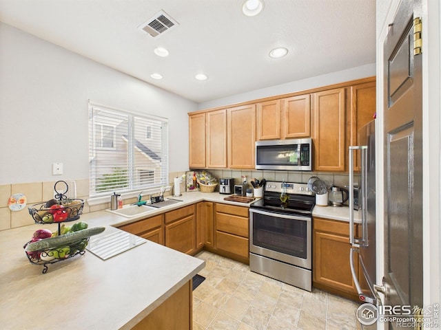 12912 Grant Cir E # A, Thornton, CO 80241 - kitchen featuring appliances with stainless steel finishes, light countertops, backsplash, and recessed lighting