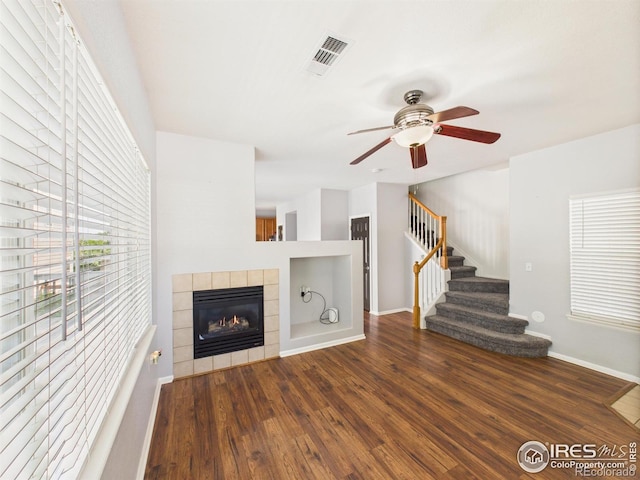 12912 Grant Cir E # A, Thornton, CO 80241 - unfurnished living room with wood finished floors, ceiling fan, a tiled fireplace, and stairs