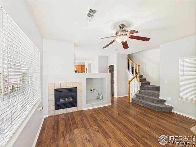 12912 Grant Cir E # A, Thornton, CO 80241 - unfurnished living room featuring a ceiling fan, wood finished floors, a tile fireplace, and stairs
