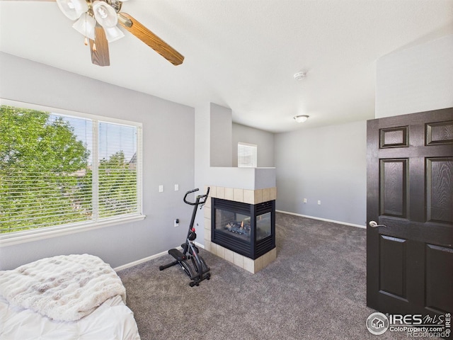 12912 Grant Cir E # A, Thornton, CO 80241 - workout room featuring a tile fireplace, carpet floors, and a ceiling fan