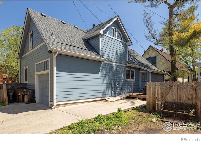 1605 17th St, Boulder, CO 80302 - rear view of property featuring a shingled roof, a garage, driveway, and a wooden deck