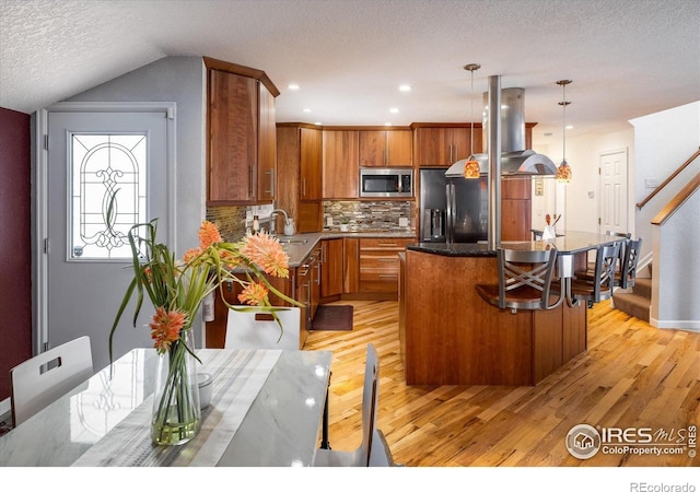 1605 17th St, Boulder, CO 80302 - kitchen featuring stainless steel microwave, island exhaust hood, light wood finished floors, fridge with ice dispenser, and a center island