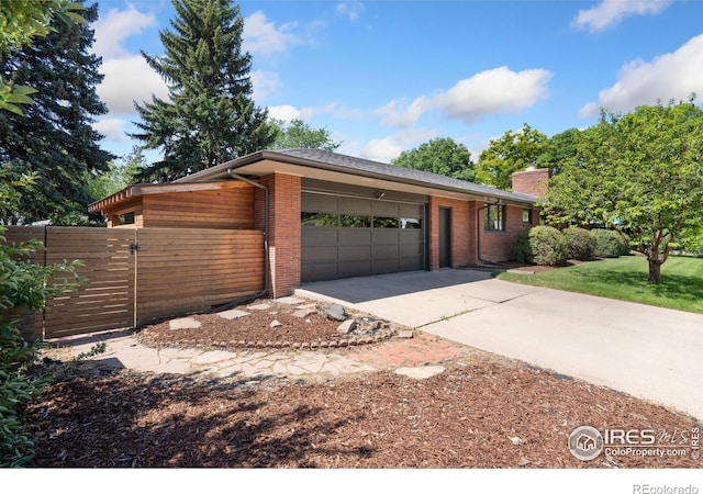 600 Monte Vista Ave, Fort Collins, CO 80521 - view of front of home featuring a garage, concrete driveway, a chimney, and brick siding
