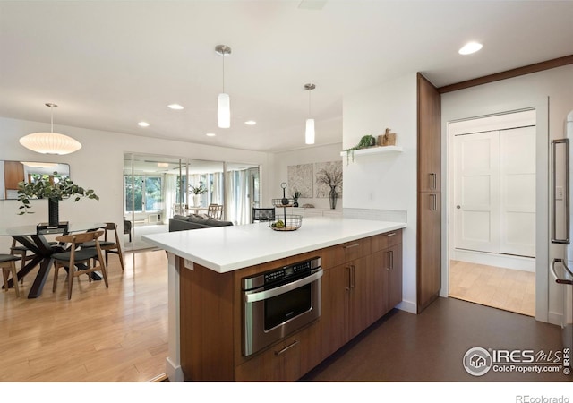 600 Monte Vista Ave, Fort Collins, CO 80521 - kitchen featuring light countertops, a peninsula, light wood-style flooring, brown cabinetry, and recessed lighting