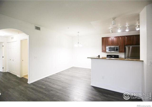 3155 Blue Sky Cir Unit 16-103, Erie, CO 80516 - kitchen with stainless steel appliances, arched walkways, dark wood-type flooring, and a peninsula