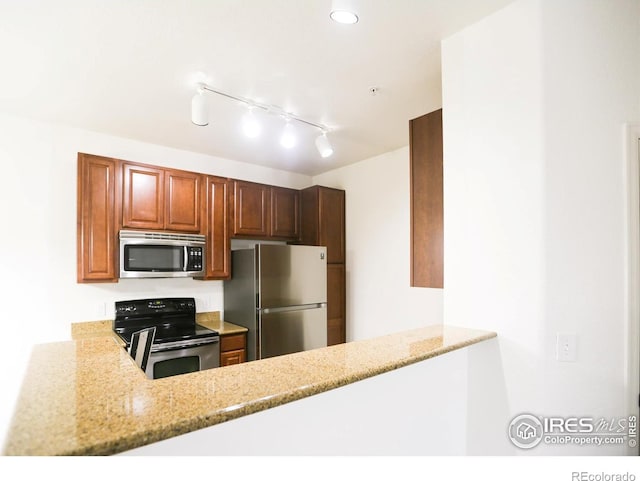 3155 Blue Sky Cir Unit 16-103, Erie, CO 80516 - kitchen featuring stainless steel appliances, light stone countertops, and a peninsula