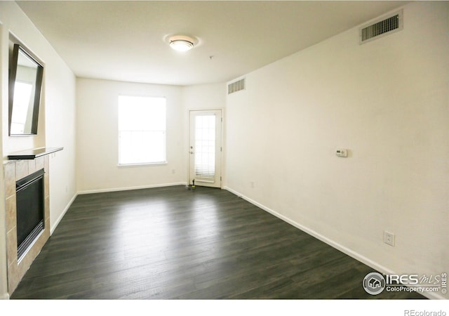 3155 Blue Sky Cir Unit 16-103, Erie, CO 80516 - unfurnished living room featuring dark wood finished floors and a tiled fireplace