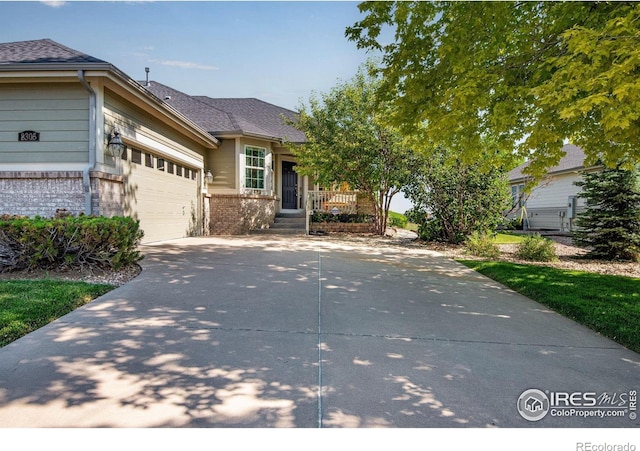 8305 E 149th Dr, Thornton, CO 80602 - view of front of house featuring brick siding, driveway, a garage, and roof with shingles