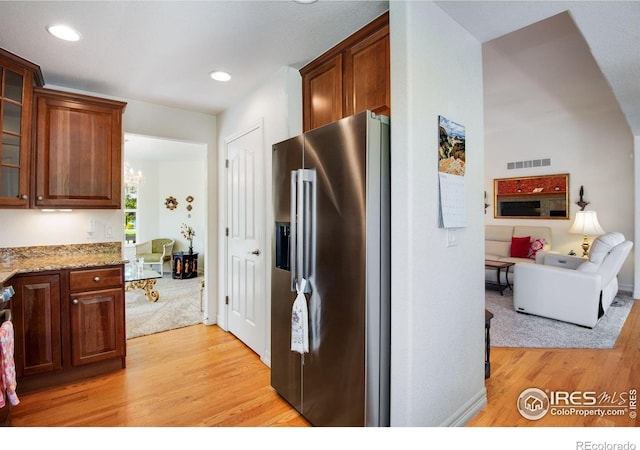 8305 E 149th Dr, Thornton, CO 80602 - kitchen with stainless steel refrigerator with ice dispenser, light wood-style floors, glass insert cabinets, light stone countertops, and recessed lighting