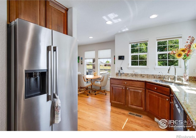 8305 E 149th Dr, Thornton, CO 80602 - kitchen with stainless steel appliances, light wood-style flooring, plenty of natural light, brown cabinets, and recessed lighting
