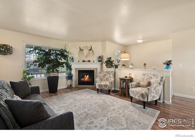 4521 Mesa Verde Dr, Greeley, CO 80634 - living room with wood finished floors, a tiled fireplace, and a textured ceiling