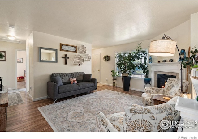 4521 Mesa Verde Dr, Greeley, CO 80634 - living room with wood finished floors, a fireplace, and a textured ceiling